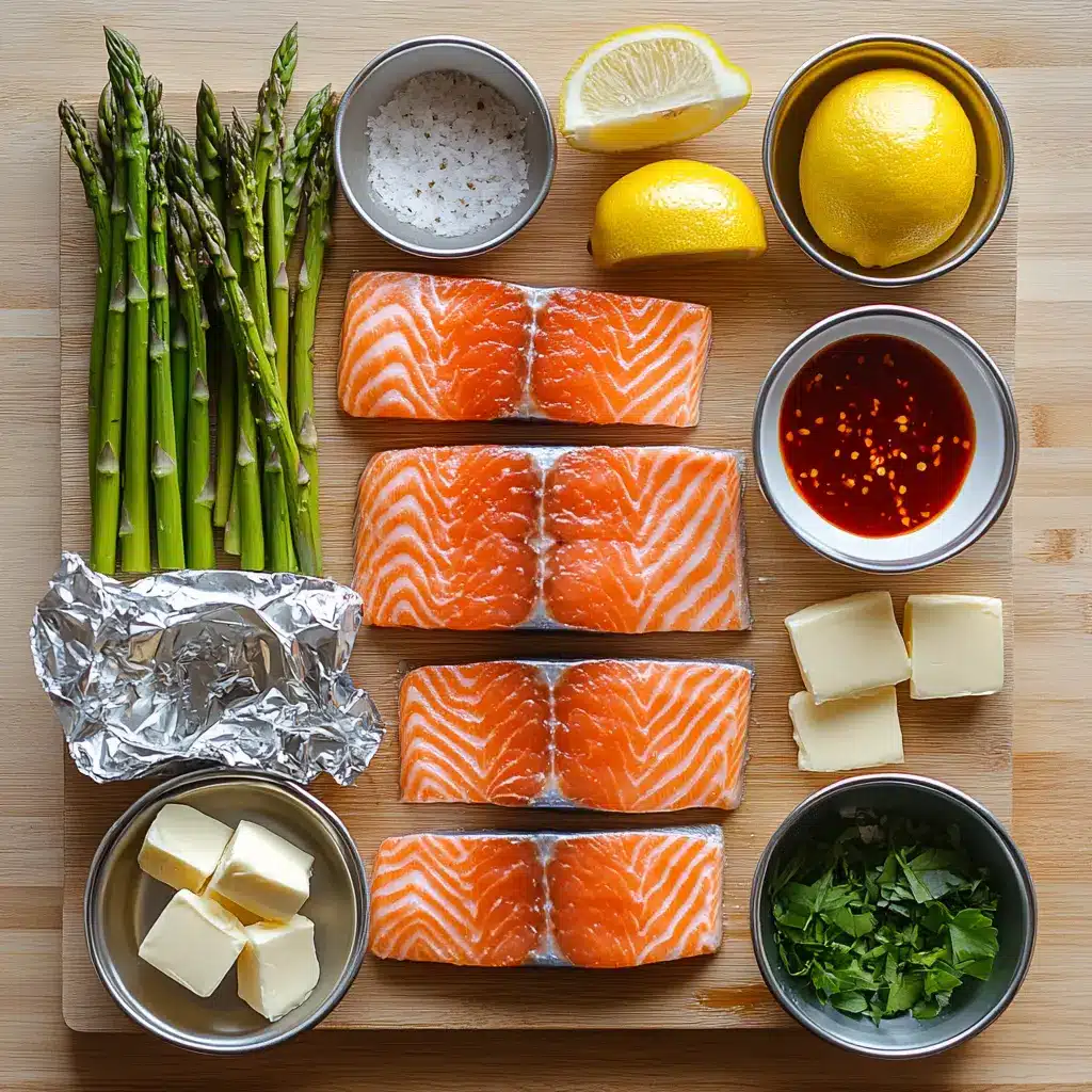 Arrangement of fresh ingredients for salmon and asparagus foil packs: salmon fillets, green asparagus spears, lemon slices, and sprigs of dill.